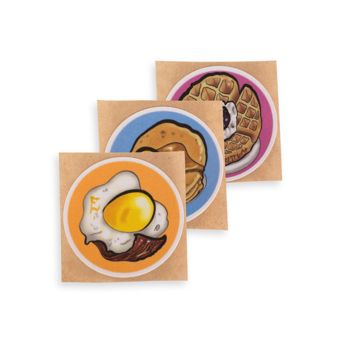 Tasty Pasties nipple covers set with breakfast food designs on kraft paper packaging