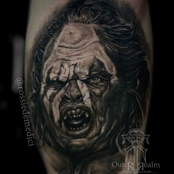 A black and grey tattoo by Rossie de Medici showing Lurtz the Uruk-hai growling.