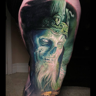 A colour realism tattoo of the King of the Dead with glowing green around him.
