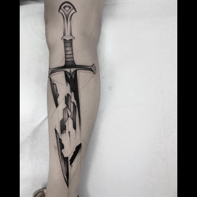 A blackwork tattoo by Frank Carrilho on someone's leg showing the broken blade of Narsil