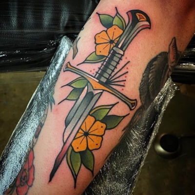A traditional tattoo by Goldsmith Tattooer showing a broken Narsil with flowers.