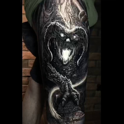 A black and grey dark realism tattoo of the Balrog on someone's thigh.